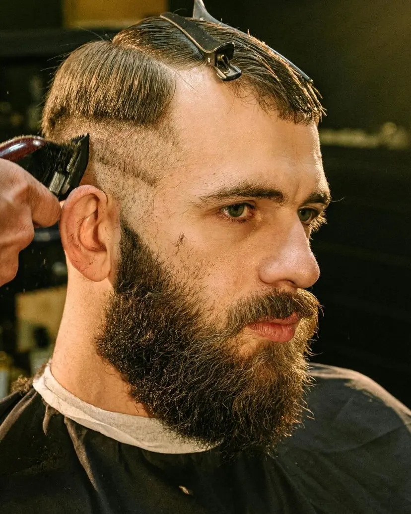 Barber running clippers along a bearded client's fade at a Santa Monica barber shop