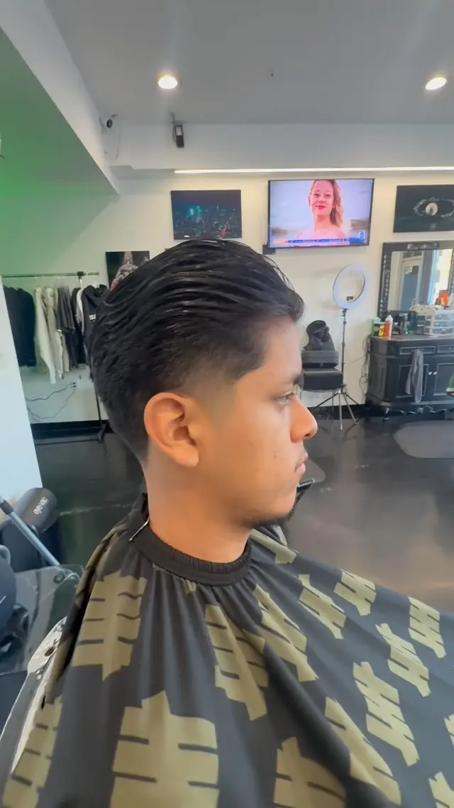 Slicked-back haircut with a low taper, cut at Ocean Park Barbershop
