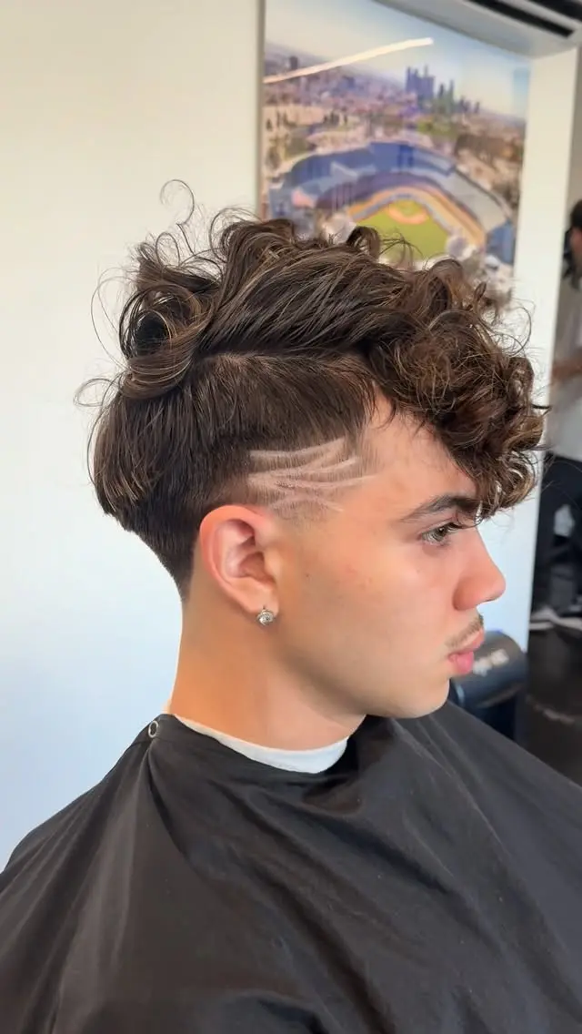 Curly top with a taper and razor design at Ocean Park Barbershop