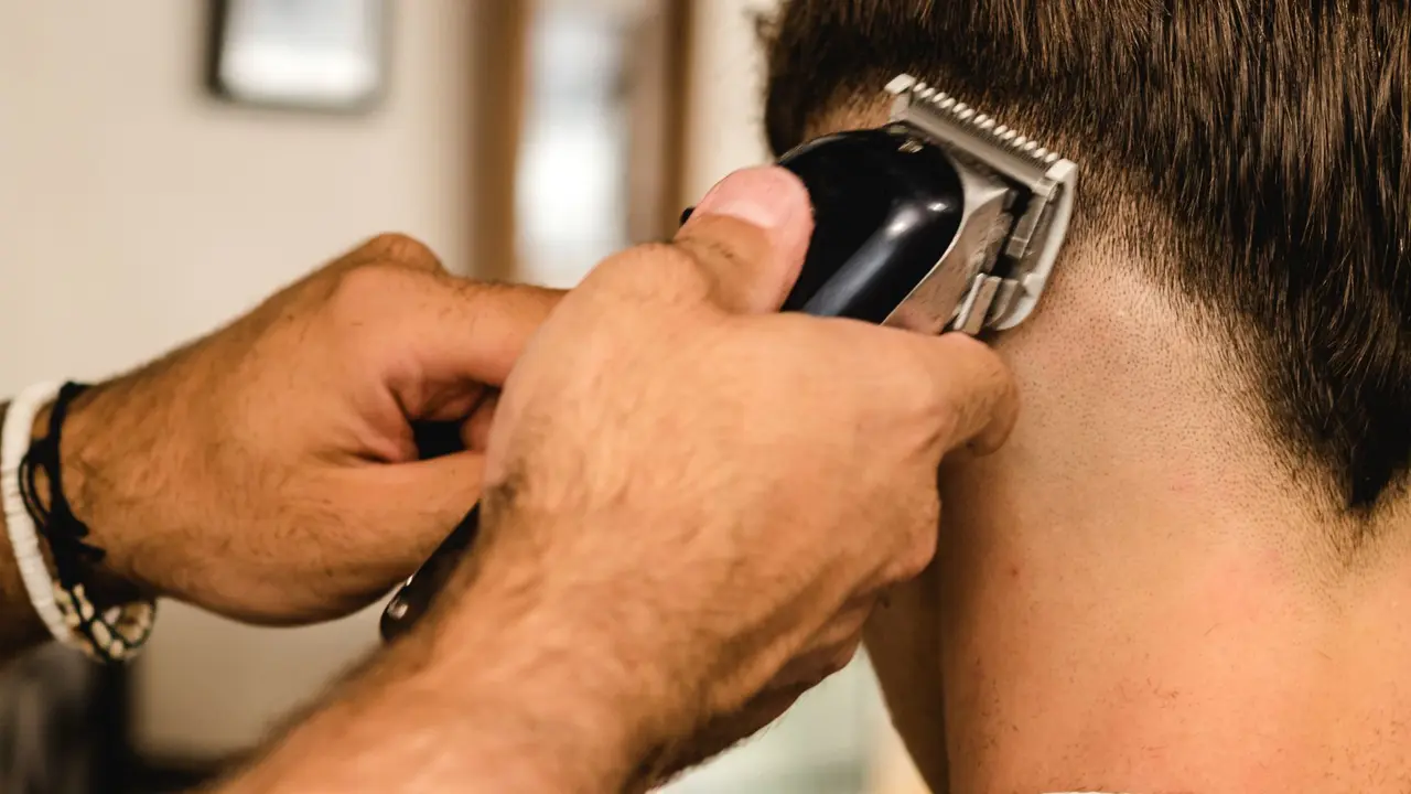 Clippers blending a fade at the back of a client's neck