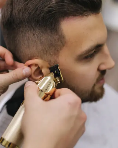 Gold trimmer edging a beard along the cheek