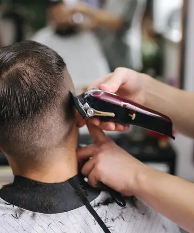 Clippers shaping the back of a fade haircut